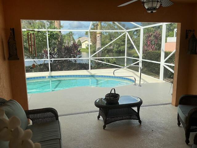 view of swimming pool featuring ceiling fan, a lanai, and a patio