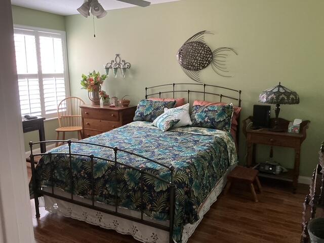 bedroom with dark hardwood / wood-style flooring and ceiling fan