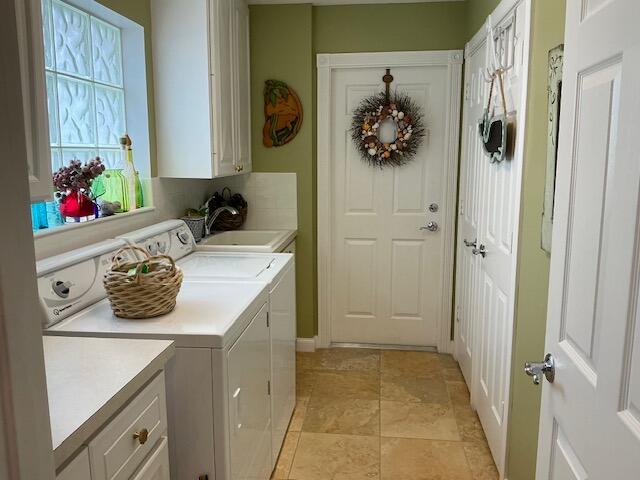 washroom with cabinets, sink, and washer and dryer