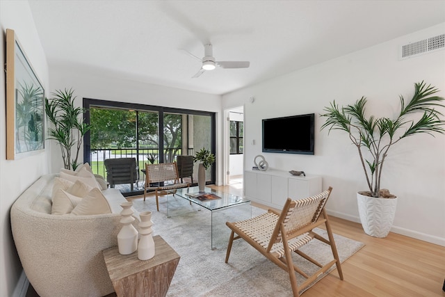 living room featuring ceiling fan and light hardwood / wood-style floors