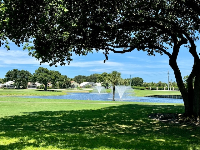 surrounding community featuring a lawn and a water view