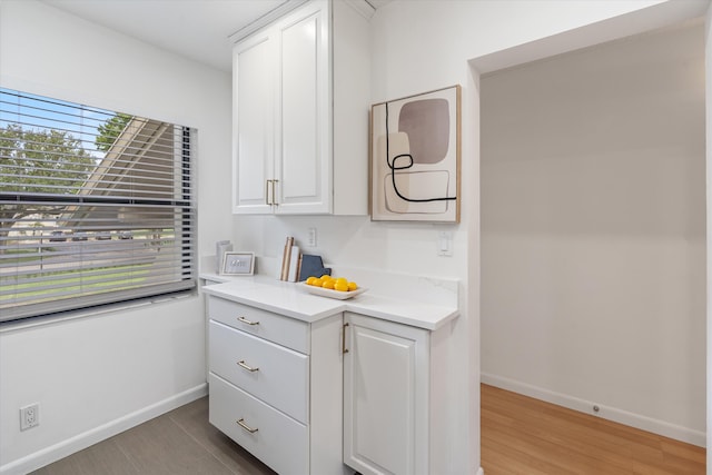 kitchen with light wood-type flooring and white cabinetry