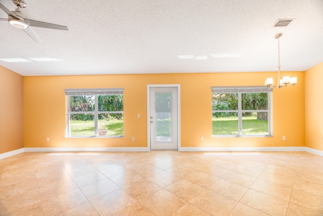 unfurnished room with ceiling fan with notable chandelier, a textured ceiling, and plenty of natural light