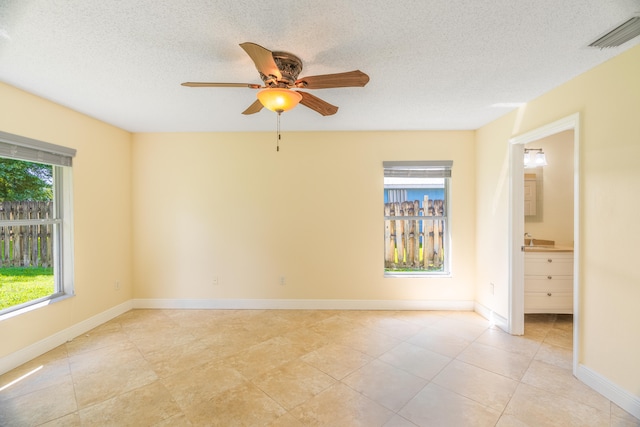 spare room with ceiling fan, a textured ceiling, sink, and light tile patterned flooring