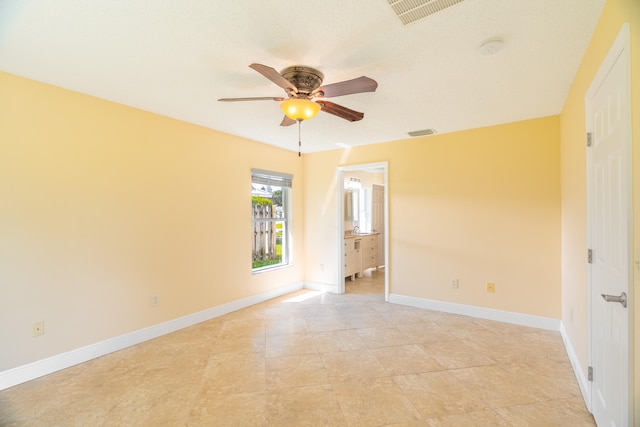 tiled spare room featuring ceiling fan