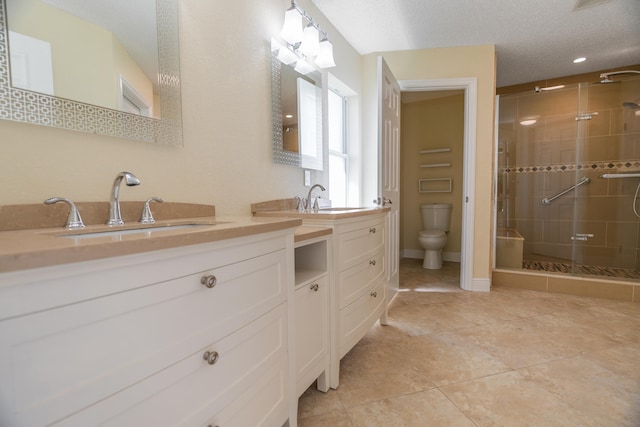 bathroom featuring tiled shower, vanity, a textured ceiling, toilet, and tile patterned floors