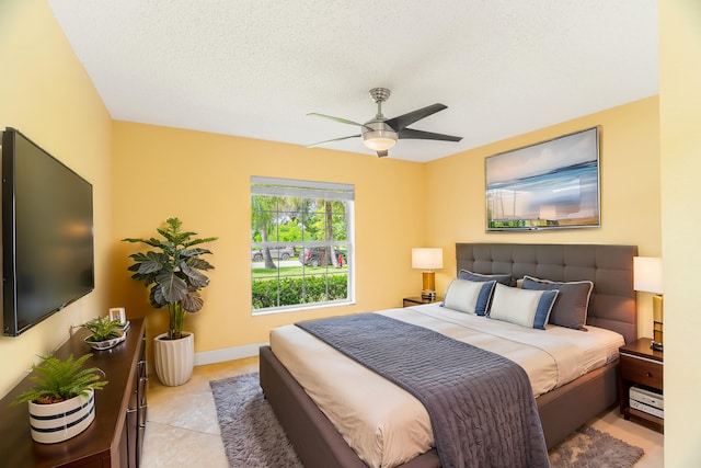 bedroom featuring ceiling fan, a textured ceiling, and light tile patterned flooring