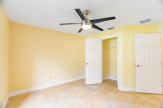 unfurnished bedroom with a closet, ceiling fan, light tile patterned flooring, and a textured ceiling