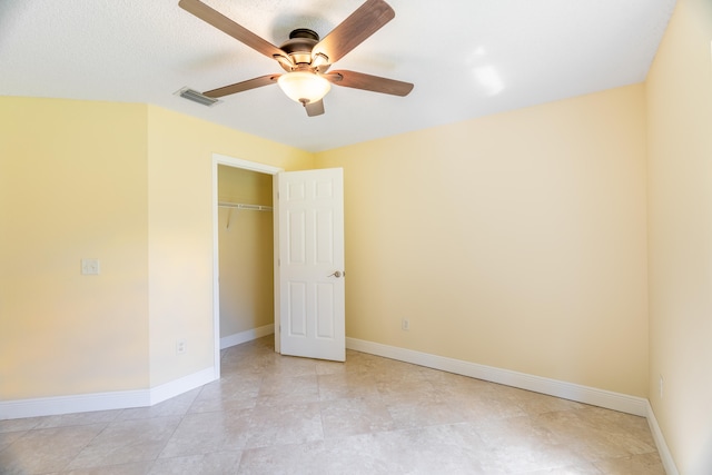 interior space with ceiling fan, a textured ceiling, and a closet