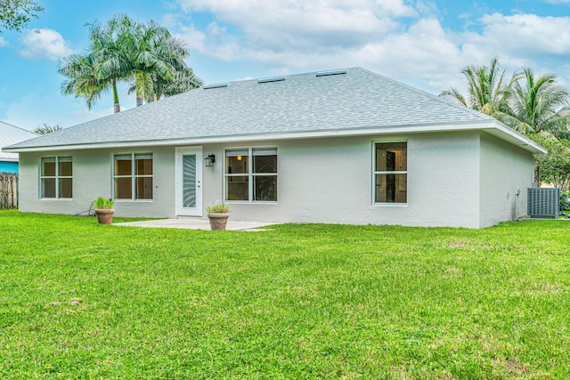 back of house featuring a yard, central AC unit, and a patio area