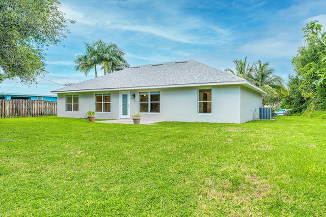 rear view of house featuring a lawn, cooling unit, and a patio area