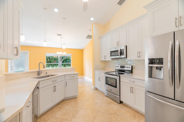 kitchen with sink, stainless steel appliances, vaulted ceiling, and white cabinetry