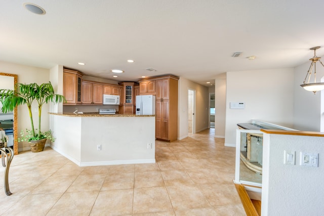 kitchen with kitchen peninsula, light stone countertops, white appliances, and hanging light fixtures