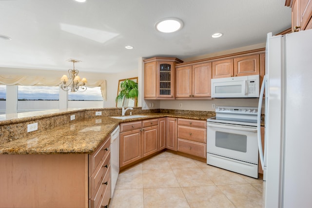 kitchen featuring pendant lighting, white appliances, an inviting chandelier, sink, and light stone countertops