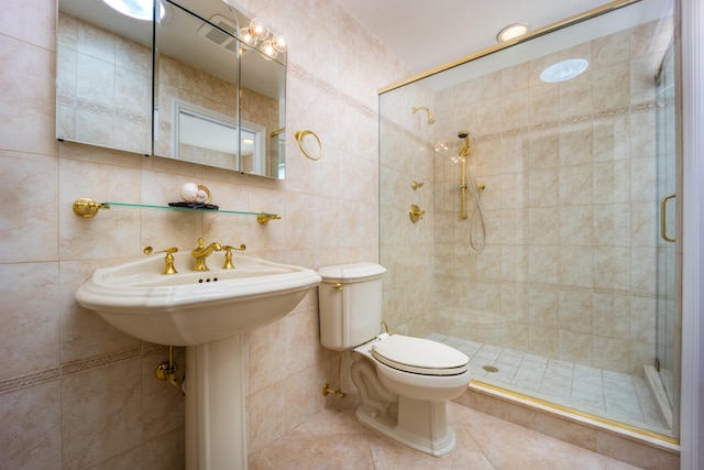 bathroom featuring tile patterned floors, toilet, tile walls, and walk in shower