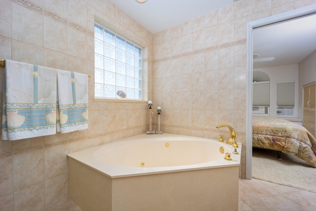 bathroom with tile patterned floors, a bathing tub, and tile walls