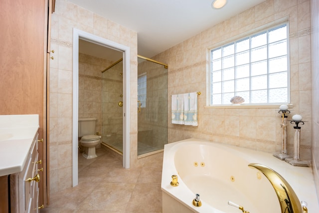 full bathroom featuring vanity, tile patterned floors, toilet, tile walls, and independent shower and bath