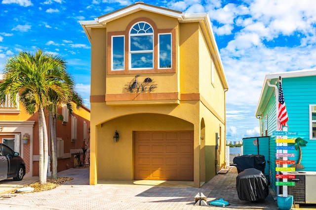 view of front of property with a garage and central AC