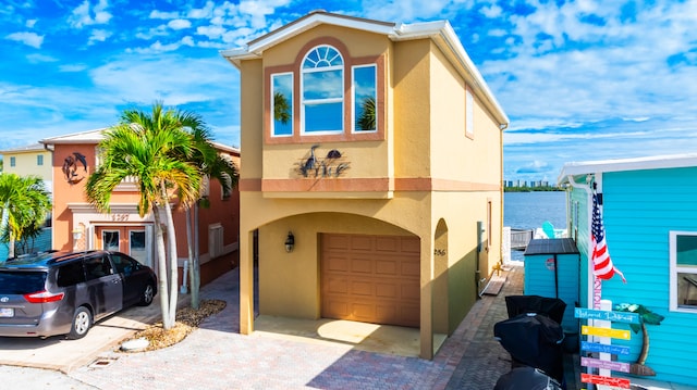 view of front of house featuring a garage and a water view