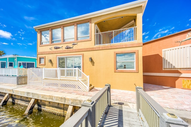 back of house with a balcony and a water view