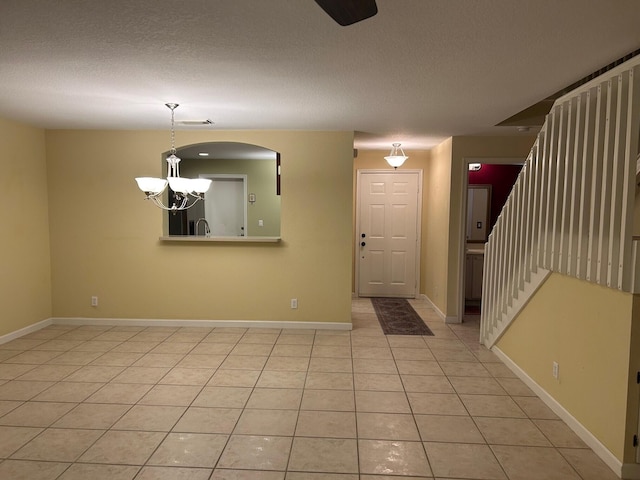 entryway with a notable chandelier and light tile patterned flooring