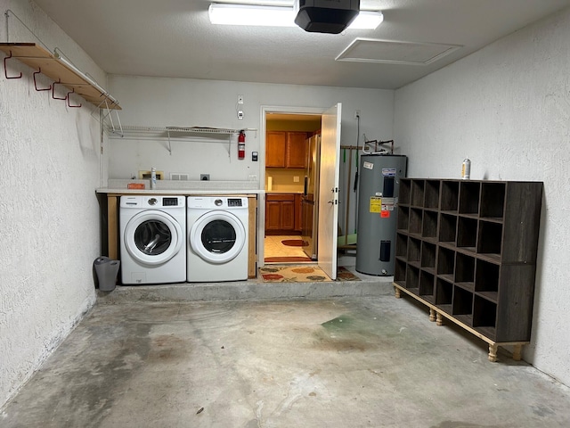 garage featuring electric water heater, separate washer and dryer, and a garage door opener