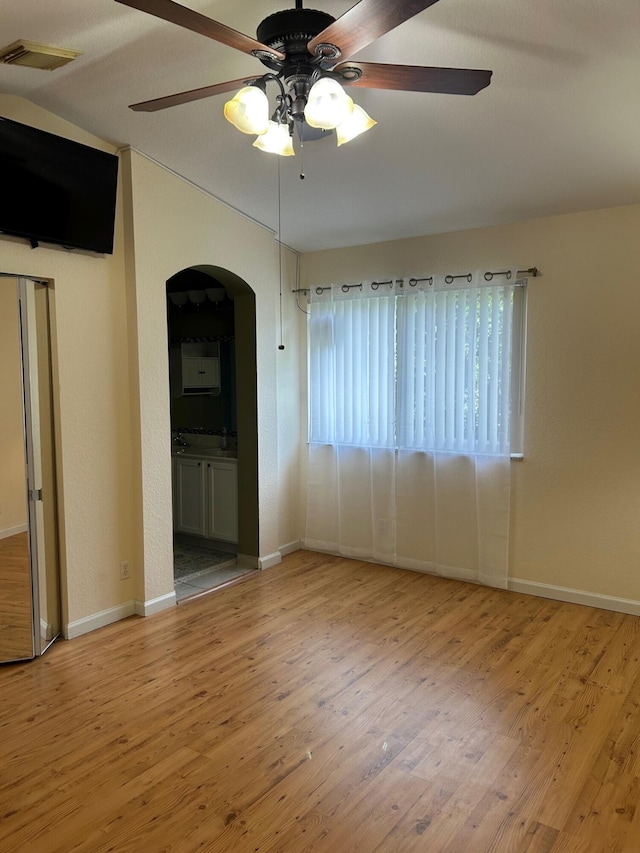 spare room with ceiling fan and light wood-type flooring