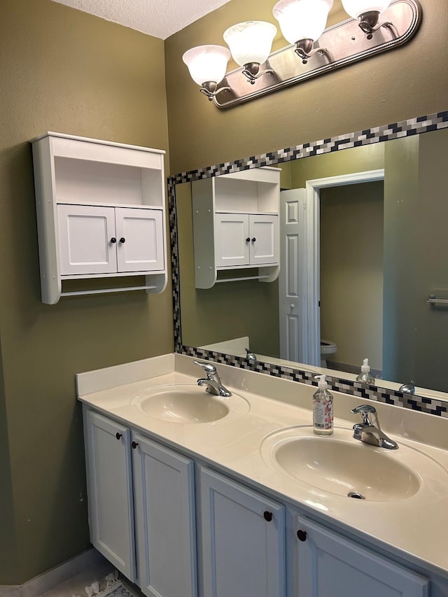 bathroom featuring vanity, a textured ceiling, and toilet