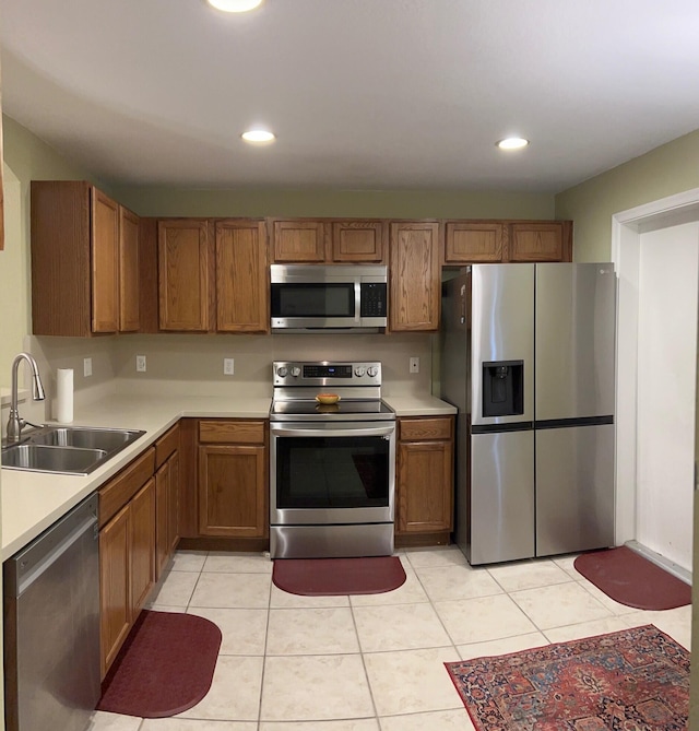 kitchen with sink, light tile patterned flooring, and stainless steel appliances