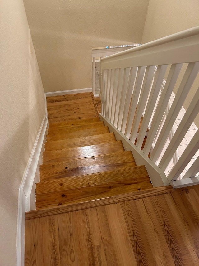 stairs featuring hardwood / wood-style flooring