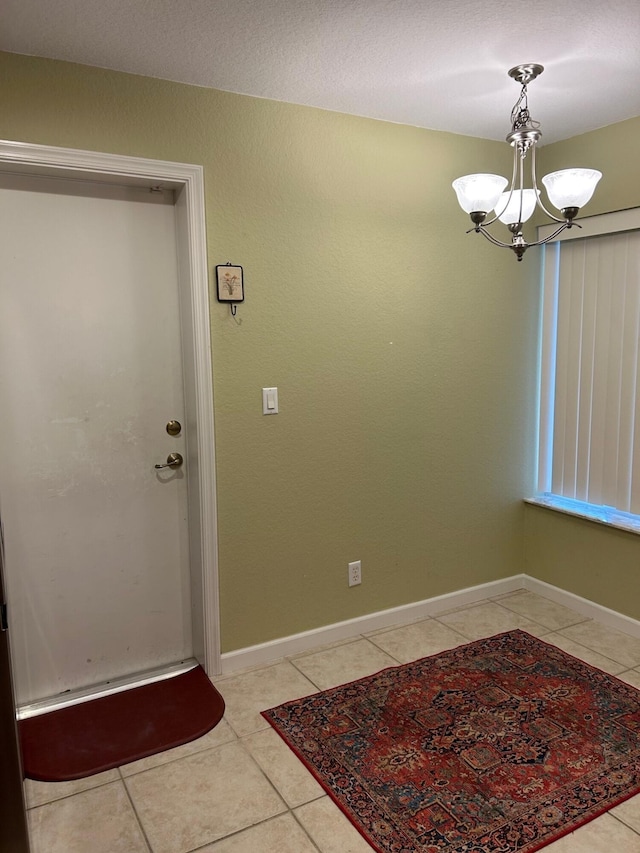 tiled entrance foyer with a notable chandelier