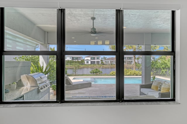 doorway with a water view and ceiling fan