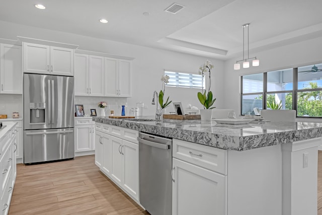 kitchen with decorative backsplash, sink, a tray ceiling, white cabinetry, and stainless steel appliances