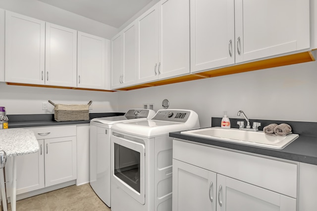 laundry room featuring cabinets, sink, light tile patterned floors, and washing machine and dryer