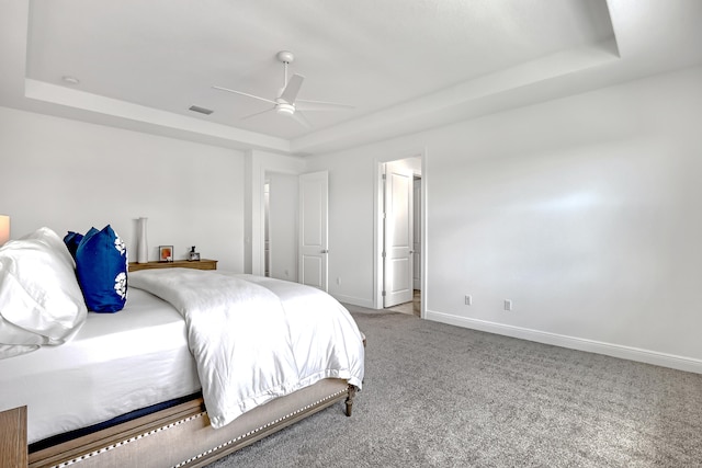 bedroom featuring ceiling fan, carpet, and a tray ceiling