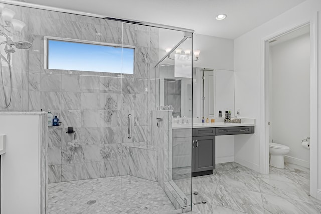 bathroom featuring toilet, a shower with shower door, and vanity