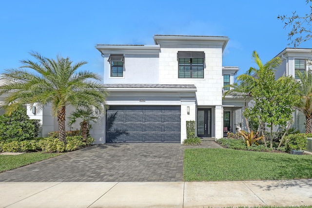 view of front of property featuring a front lawn and a garage