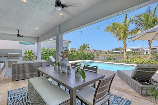 view of patio featuring ceiling fan, a grill, exterior kitchen, an outdoor hangout area, and a fenced in pool