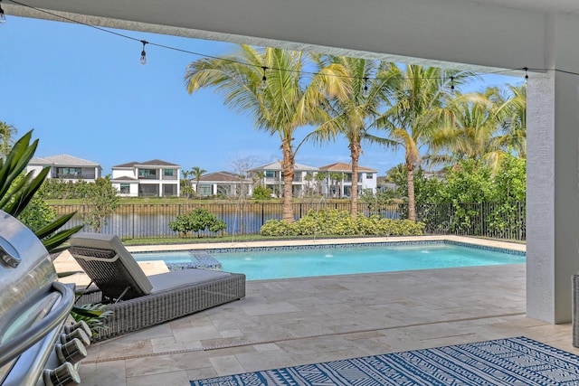 view of pool with a water view and a patio