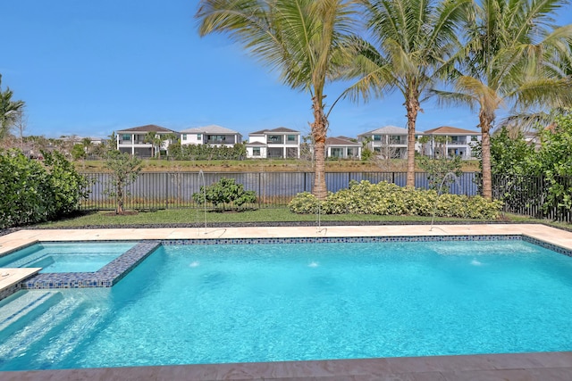 view of swimming pool featuring pool water feature and an in ground hot tub