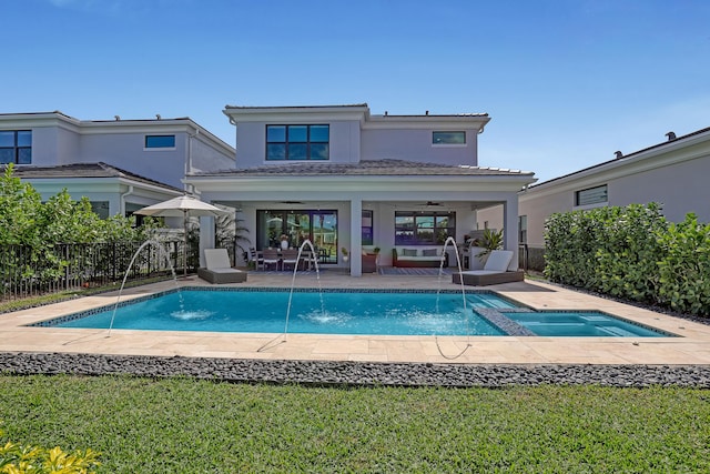 view of swimming pool with ceiling fan, an in ground hot tub, pool water feature, and a patio