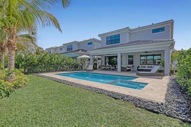 view of pool with a lawn, ceiling fan, a patio area, pool water feature, and an in ground hot tub