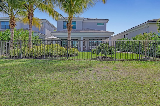 back of house featuring ceiling fan and a yard