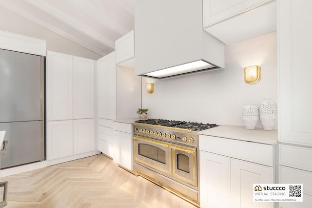 kitchen featuring white cabinets, lofted ceiling, appliances with stainless steel finishes, and light parquet floors