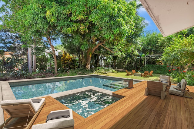 view of pool featuring an in ground hot tub and a deck