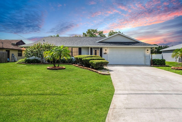 ranch-style home featuring a yard and a garage