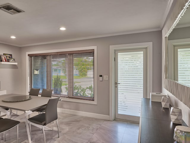 tiled dining space featuring crown molding