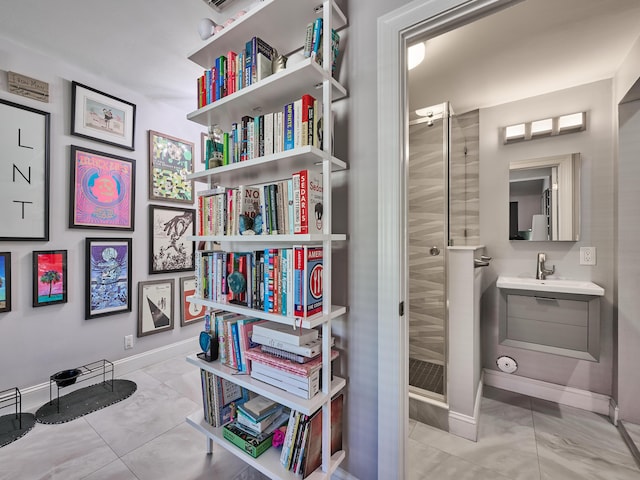 bathroom with a stall shower, baseboards, and marble finish floors