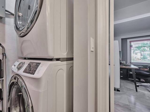 clothes washing area with stacked washer / drying machine and an office area