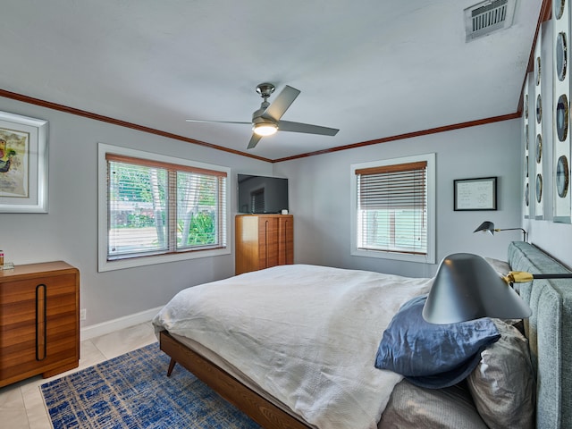 tiled bedroom featuring ceiling fan, multiple windows, and ornamental molding